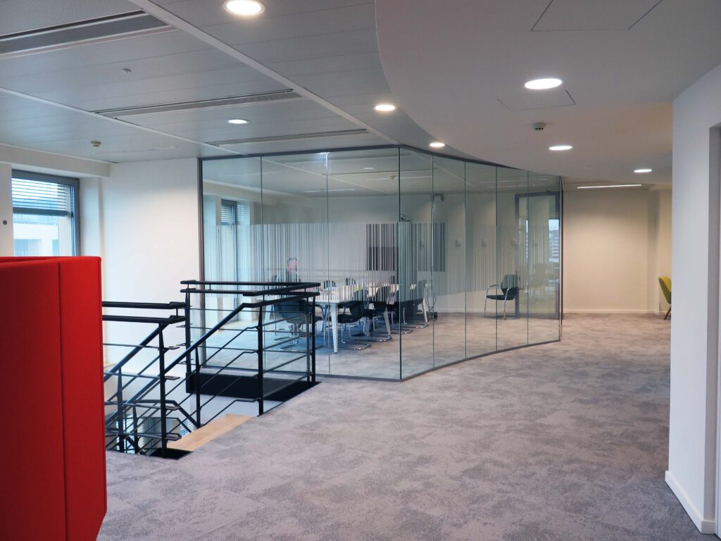 Glass conference room next to stairs leading down