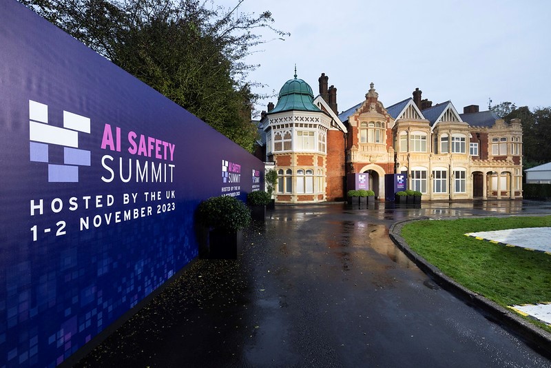 Manor House at Bletchley Park next to boarding showing the AI Safety Summit logo 