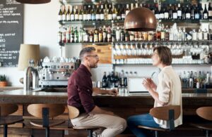 Cropped shot of two people talking in a cafe